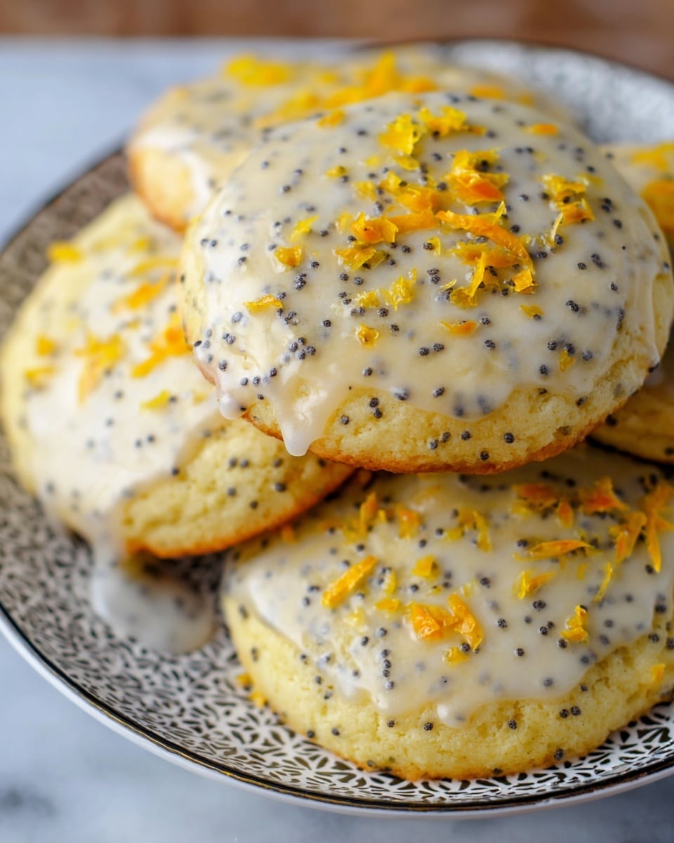 A close-up image shows a stack of round cookies with a soft, light yellow color speckled with small black poppy seeds scattered evenly throughout. The top of each cookie is lightly coated with a thin, glossy white glaze, and bright orange zest is sprinkled on top, adding a fresh pop of color and texture. The cookies are arranged on a white plate with a delicate black pattern around the edge, sitting on a white marbled surface. The image focuses on the top and sides of the cookies, highlighting their moist texture and the contrast of the black seeds and orange zest on the pale cookie base. Photo taken with an iphone --ar 4:5 --v 7