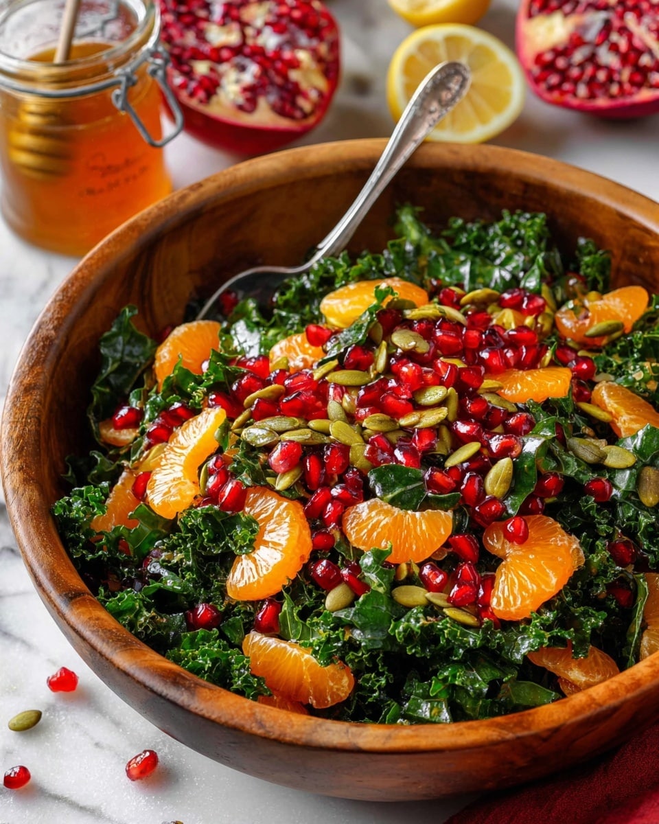 A large wooden bowl holds a fresh salad with three visible layers: a base of dark green, textured kale leaves, a middle layer of bright orange mandarin segments spread evenly, and a top layer scattered with shiny, ruby red pomegranate seeds and pale green pumpkin seeds, adding a mix of smooth and crunchy textures. The salad is on a white marbled surface, near a jar of honey and slices of lemon, with a partially opened pomegranate in the background. A silver spoon rests inside the bowl, ready for serving. Photo taken with an iphone --ar 4:5 --v 7