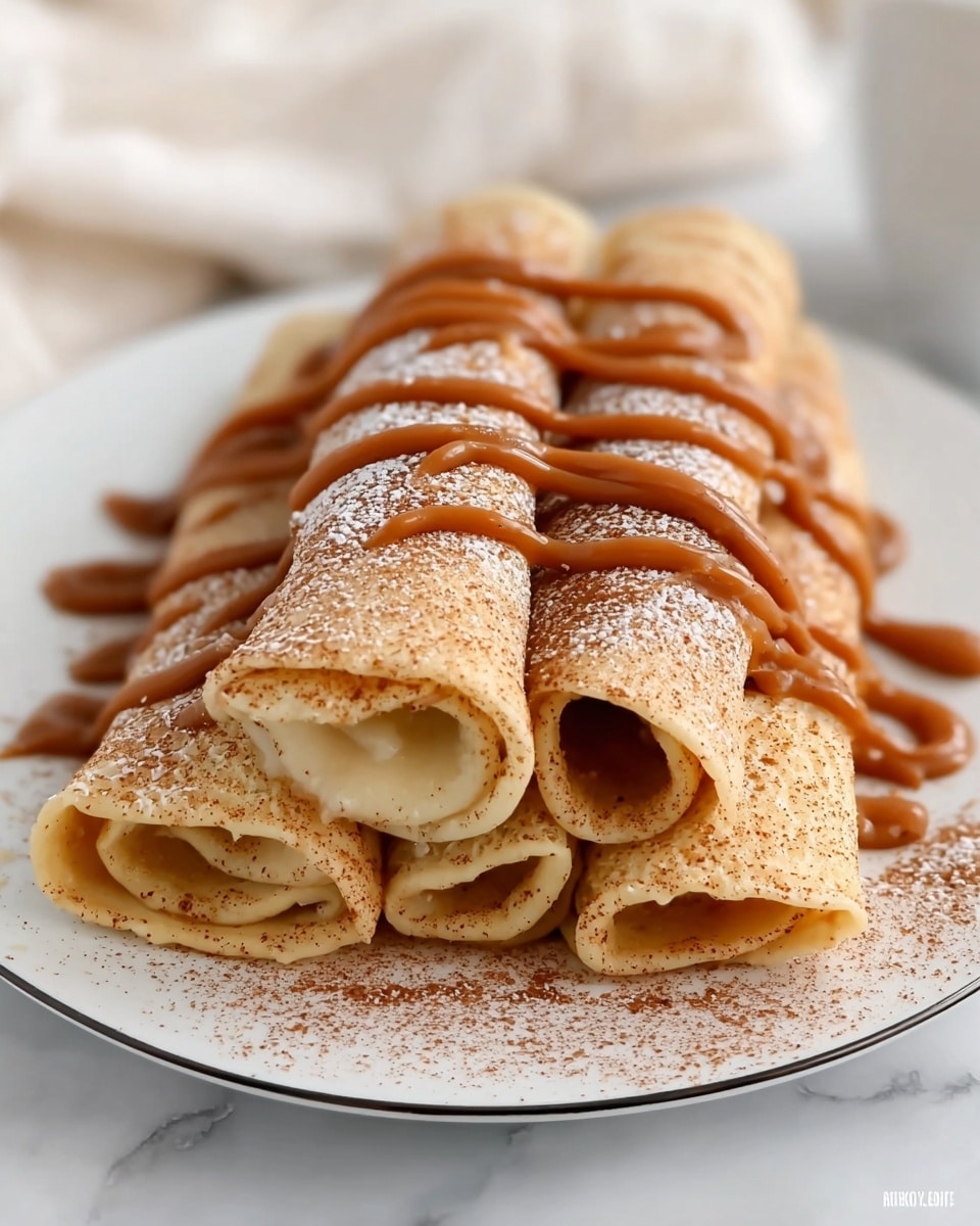 A stack of five rolled crepes arranged in two layers on a white plate with a thin black rim; three crepes form the bottom layer, and two crepes are stacked on top, all light golden brown with a soft, slightly textured surface dusted with a fine layer of cinnamon powder. Smooth caramel-colored sauce is drizzled in thick, wavy lines across the top and sides of the crepes, adding a glossy contrast to the matte powdered cinnamon. The plate is placed on a white marbled surface, and a soft white cloth is blurred in the background. photo taken with an iphone --ar 4:5 --v 7