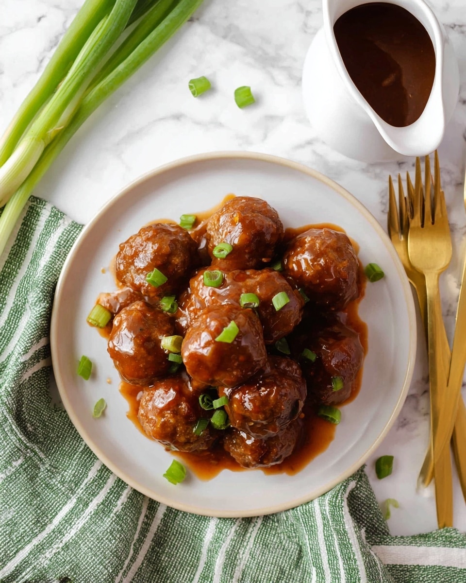 A white round plate filled with two layers of glossy brown meatballs covered in a thick, shiny sauce, garnished with small pieces of fresh green onion on top and around. There is a white jug filled with extra sauce to the right, and three gold forks placed on the left side of the plate. The plate is set on a white marbled surface with a green and white striped cloth partially visible at the bottom left, and some green onions placed at the bottom right. Photo taken with an iphone --ar 4:5 --v 7